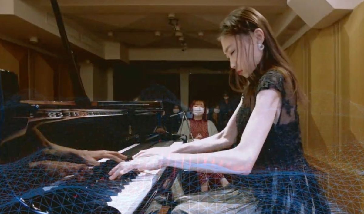 Pianist with a projected mesh overlay during Frisson Waves