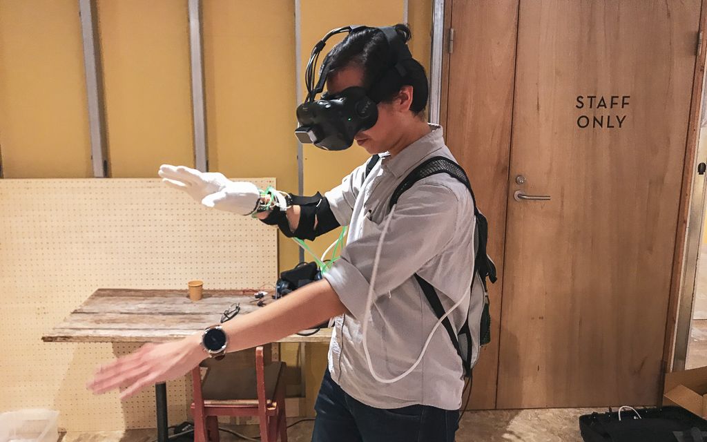 Person with a VR headset and sensor gloves