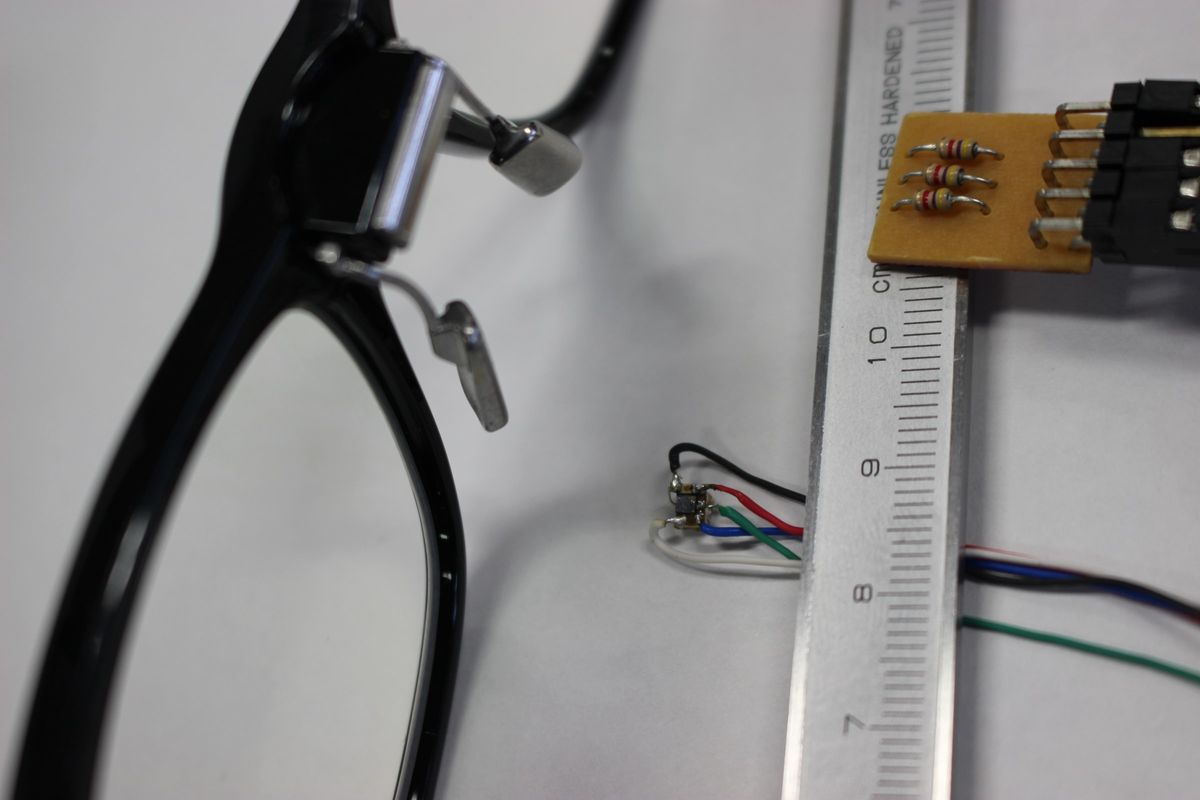Glasses prototype next to a ruler and a small sensor board